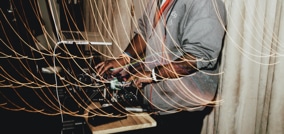 manos en mesa de mezcla con efectos luminosos de noche fiesta