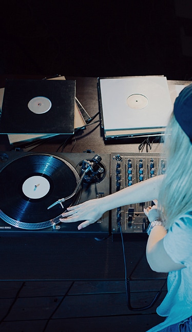 persona haciendo mezclas en una mesa de dj con ordenador