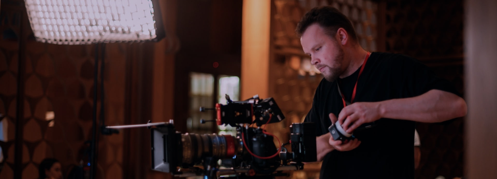Persona trabaja con una cámara profesional de cine en un set interior con iluminación artificial
