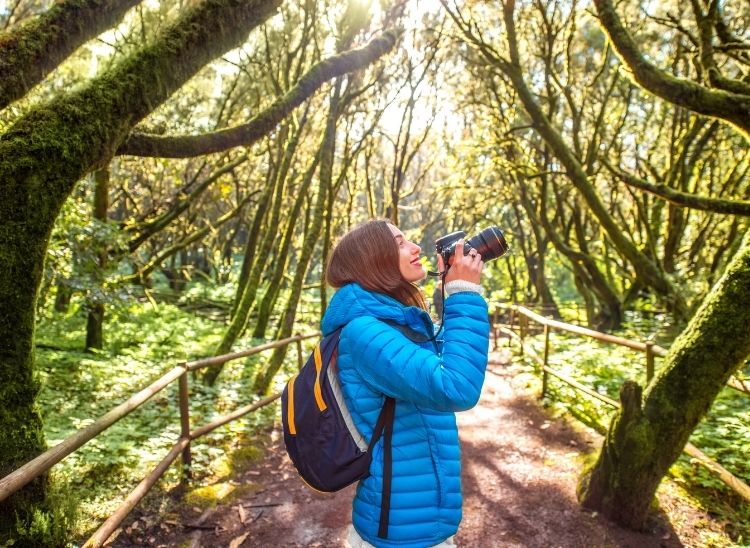 fot&oacute;grafa de naturaleza tomando fotos en el exterior con c&aacute;mara profesional