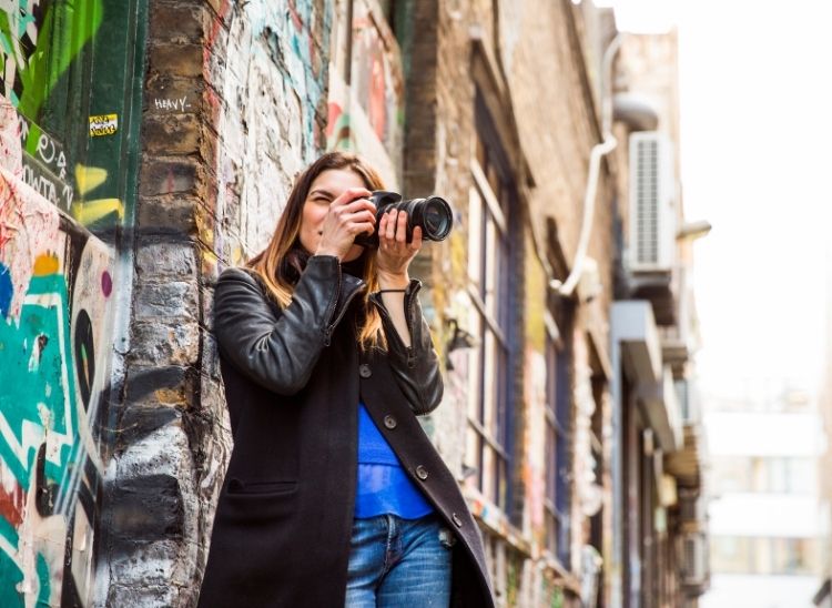 persona con cámara capturando escena urbana en fotografía callejera