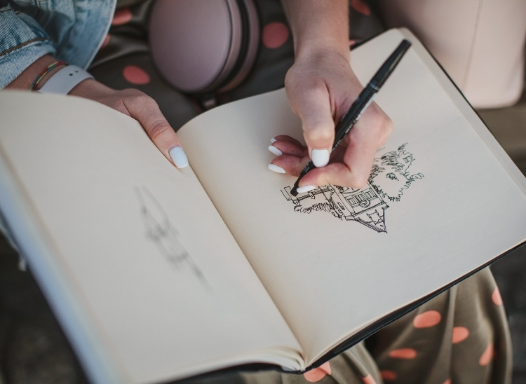 La fotograf&iacute;a muestra a una joven dibujando un edificio en su sketchbook